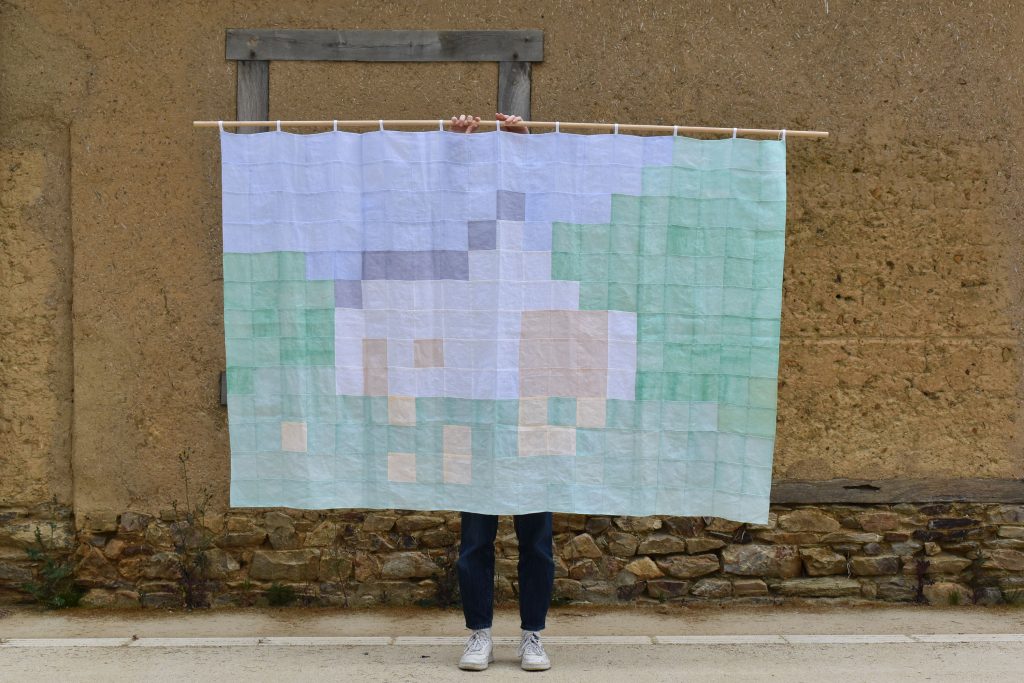 Tenture textile mettant en évidence la grille d'une image pixelisée